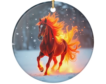 May include: A round ceramic ornament featuring a running horse with a fiery mane and tail. The horse is a reddish-brown color, set against a snowy background. The ornament has a gold string for hanging.