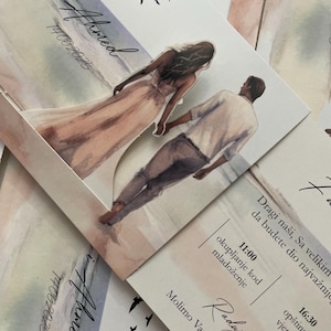 May include: Wedding invitation cards with a watercolor illustration of a couple walking on a beach, with the names "Ahida i Ahmed" and the date "14062025" printed on them. The cards have a soft, pastel color scheme and include text in a foreign language.
