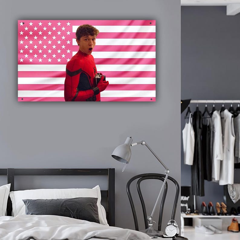 以下が含まれることがあります： ピンクと白のアメリカ国旗のデザインと、赤と黒のコスチュームを着た人物の肖像画が描かれた長方形のウォールアート。その人物は口を開けて、こちらを見ています。