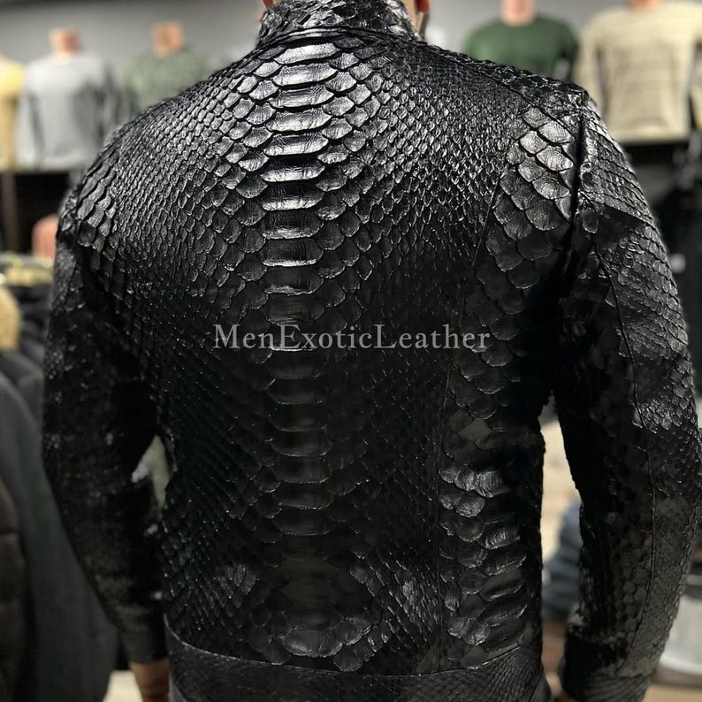 Pode incluir: Casaco de couro preto com padr&atilde;o de pele de cobra. O casaco tem gola alta e fecho de correr. O texto "MenExoticLeather" &eacute; vis&iacute;vel. O casaco parece ser feito de couro de alta qualidade.