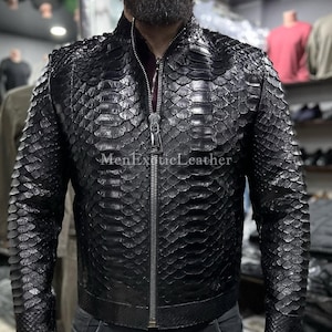 Könnte beinhalten: Schwarze Lederjacke mit Schlangenmuster. Die Jacke hat einen Reißverschluss und einen Stehkragen. Der Text "MenExoticLeather" ist auf der Jacke zu sehen.