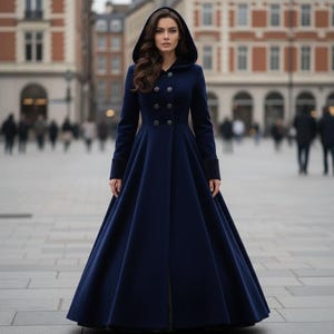 Elegant woman modeling navy blue velvet long hooded coat in winter city street