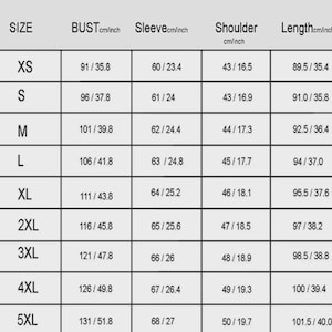 Puede incluir: Una tabla de tallas de ropa con medidas en cent&iacute;metros y pulgadas. Incluye tallas de XS a 5XL, con medidas de busto, manga, hombro y largo. El fondo es de color beige claro.