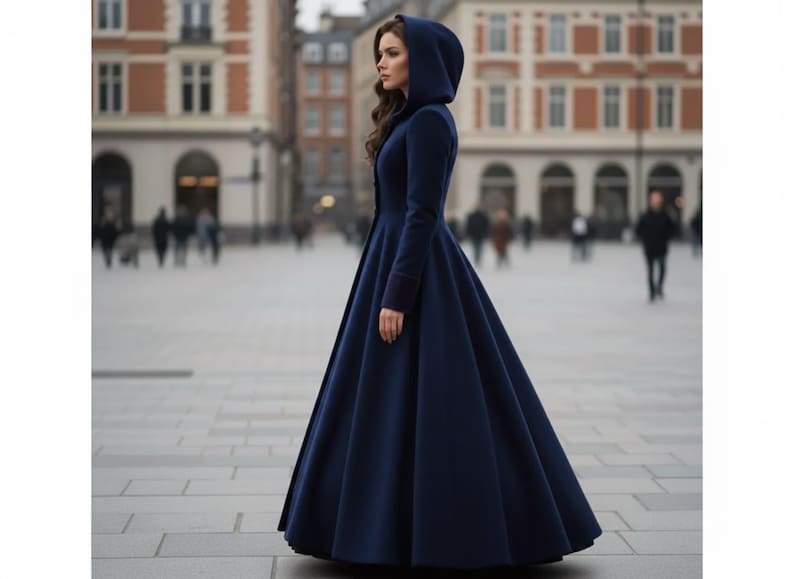 May include: A floor-length, dark navy blue coat featuring a fitted bodice, long sleeves, and a large hood. The garment has a structured silhouette that flares out from the waist down to the hem, creating a full, pleated skirt effect.