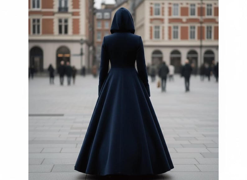 May include: A floor-length, dark navy blue coat featuring a fitted bodice, long sleeves, and a full, flared skirt. The garment includes an attached hood that rests over the head, creating a structured silhouette that reaches down to the ground.