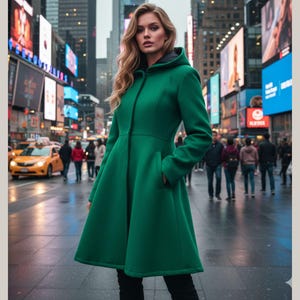 May include: A woman wearing a long, emerald green coat with a hood, standing in a city street. The coat has a fitted waist and flared skirt. The background features bright billboards, buildings, and people walking on the sidewalk.