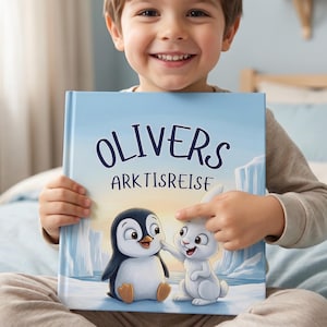 May include: A children's book titled "OLIVERS ARKTISREISE" features a cartoon penguin and rabbit on a light blue background with icebergs. The book is held by a smiling child.