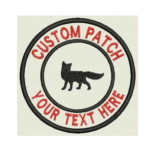 Peut inclure: Un patch brodé noir et blanc avec une silhouette de renard au centre. Le texte "CUSTOM PATCH YOUR TEXT HERE" est en rouge autour de l'extérieur du cercle.