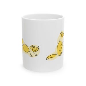 Könnte beinhalten: Ein weißer Keramikbecher mit einer minimalistischen Strichzeichnung eines gelben Frettchens in zwei verschiedenen Posen. Ein Frettchen ist in einer horizontalen, verspielten Haltung dargestellt, während das andere aufrecht in vertikaler Position steht.