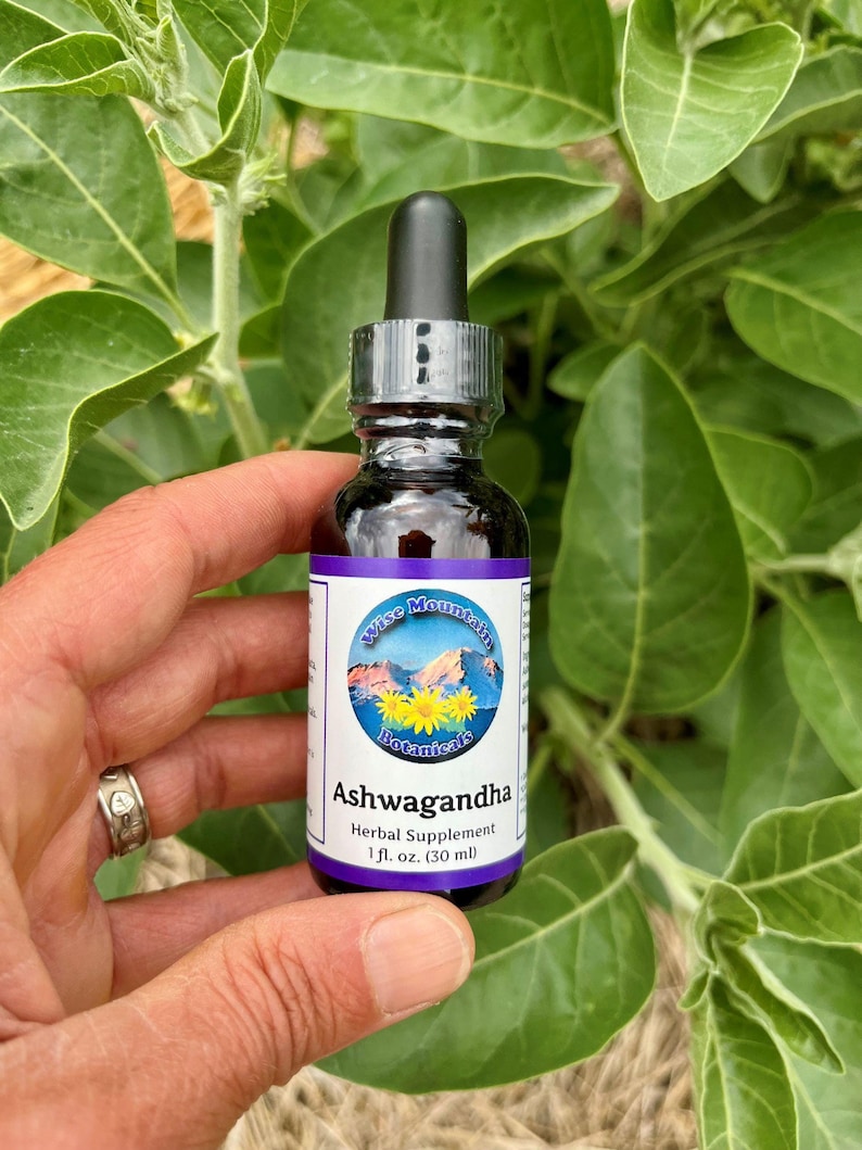 May include: A small brown glass bottle with a dropper top. The bottle is labeled "Wise Mountain Botanicals Ashwagandha Herbal Supplement 1 fl. oz. (30 ml)".