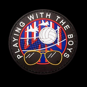 May include: A circular black patch featuring the white text PLAYING WITH THE BOYS. The center displays a volleyball, a net, two white fighter jets, and yellow-rimmed aviator sunglasses over a red and blue striped background.