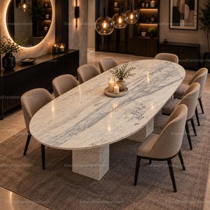 May include: An oval dining table with a white and grey marble top and a matching marble pedestal base, surrounded by ten upholstered chairs with dark wooden legs. The table surface features natural stone veining and a smooth, polished finish.