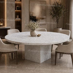 May include: A contemporary dining set with a large, circular marble table and a square base. Six upholstered chairs with wooden legs are arranged around the table. The room has neutral tones, with a vase of flowers and a small bowl.