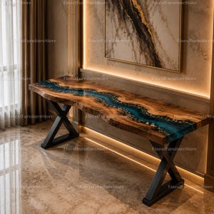 Puede incluir: Una mesa consola con un tablero de madera natural de borde vivo y una incrustación central de resina azul que simula un río con piedras incrustadas. La mesa se apoya sobre dos patas de metal negro en forma de X.