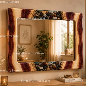 May include: A rectangular wall mirror featuring a thick frame made of natural wood with deep reddish-brown grain patterns and sections embedded with smooth, multi-colored river stones encased in a clear, glossy resin finish.