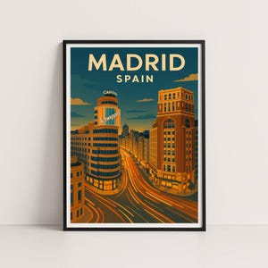 Puede incluir: Una impresión artística enmarcada que presenta una ilustración estilizada de Madrid, España. La obra de arte muestra edificios y una escena callejera con el texto "MADRID SPAIN" en la parte superior. La paleta de colores incluye tonos de naranja, amarillo y azul.