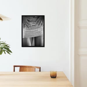 May include: Black and white framed photograph featuring a close-up of a silver, rhinestone-studded mini skirt. The hands are placed on the waist, with long, manicured nails and rings. The image is a study in texture and light.