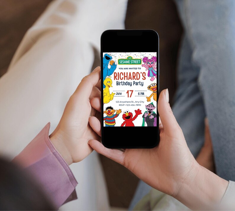 May include: A black smartphone displays a colorful Sesame Street birthday party invitation. The invitation features the text "RICHARD'S Birthday Party" with the date June 17 and the time 6 PM. Sesame Street characters are also visible.