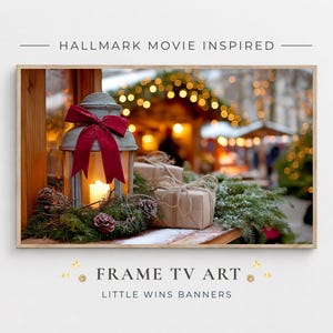 Puede incluir: Una impresión enmarcada con una escena festiva. Una linterna encendida con un lazo rojo se encuentra entre ramas de pino y piñas. Dos regalos envueltos están en el fondo. El texto "HALLMARK MOVIE INSPIRED" y "FRAME TV ART" están en la parte superior e inferior.