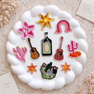 Toppe ricamate a tema deserto occidentale: cactus, chitarra e cowboy.