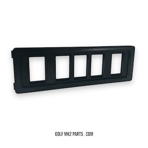 May include: A black plastic panel with five rectangular openings. The panel has a textured surface and is designed for automotive use. The text "GOLF MK2 PARTS . COM" is printed at the bottom.