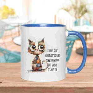 May include: White ceramic mug with a blue handle and rim, featuring a cartoon cat design. The mug has the text: "I'M NOT SURE HOW MANY COFFEES MAKE YOU HAPPY. BUT SO FAR IT'S NOT TEN." The cat is made of patchwork. A fun gift for coffee lovers.