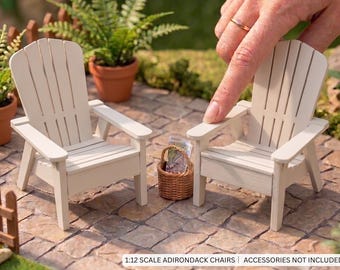 May include: Two miniature off-white Adirondack chairs in 1:12 scale, featuring a slatted backrest and wide armrests. A small brown woven basket sits between the chairs. The text 1:12 SCALE ADIRONDACK CHAIRS | ACCESSORIES NOT INCLUDED is visible.