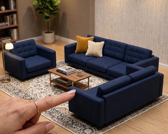 May include: A miniature 1:12 scale living room furniture set featuring dark blue sofas and an armchair with tufted cushions. The set includes a rectangular wooden coffee table with a lower shelf. Text on the image reads 1:12 SCALE LIVING ROOM SOFAS | ACCESSORIES NOT INCLUDED.