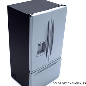 May include: A miniature refrigerator with a black exterior frame and ash gray doors. The unit features two vertical doors with handles, a built-in water dispenser on the left door, and a bottom freezer drawer. The text reads: COLOR OPTION SHOWN: ASH GRAY.