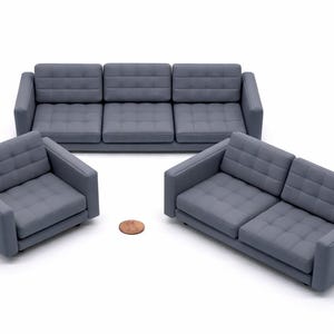 Puede incluir: Un juego de muebles de salón grises modernos, que incluye un sofá de tres plazas, un sofá de dos plazas y un sillón. Los muebles tienen un diseño acolchado. Una moneda está colocada cerca de los muebles.