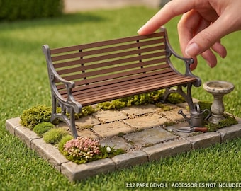 May include: A miniature 1:12 scale park bench featuring brown horizontal slats and a grey metal frame. The bench is displayed on a stone-textured base with moss, a small birdbath, a watering can, and a trowel. Text reads 1:12 PARK BENCH.