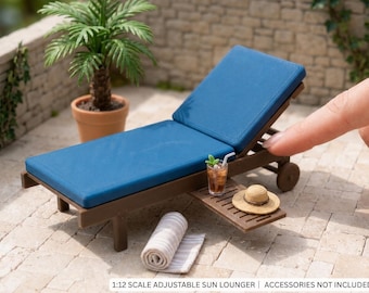 Può includere: Una sedia a sdraio regolabile in scala 1:12 con telaio marrone scuro e cuscino blu. La sdraio è dotata di vassoio laterale, ruote e design a doghe. Il testo 1:12 SCALE ADJUSTABLE SUN LOUNGER | ACCESSORIES NOT INCLUDED è stampato in basso.