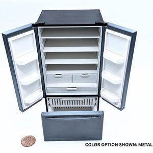May include: A miniature metallic gray refrigerator with two open doors, multiple white interior shelves, two small drawers, and a bottom freezer drawer pulled open. A copper penny is placed next to the unit for scale. Text reads: COLOR OPTION SHOWN: METALLIC GRAY.