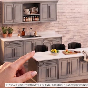 Puede incluir: Un conjunto de cocina en miniatura a escala 1:12 con armarios grises, encimera blanca e isla con tres taburetes negros. Incluye armarios superiores, fregadero y muebles bajos. Texto: 1:12 SCALE KITCHEN CABINETS & ISLAND + BARSTOOLS | ACCESSORIES NOT INCLUDED.