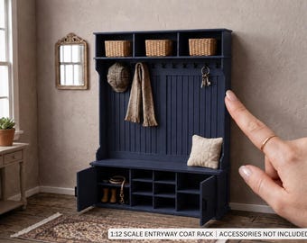 May include: A 1:12 scale navy blue wooden entryway coat rack featuring three top storage cubbies with woven baskets, a vertical paneled backboard with multiple hooks, and a lower bench with open shelving and two hinged cabinet doors.