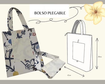 Peut inclure: Un sac fourre-tout pliable avec un motif floral bleu marine, rouge et jaune sur fond blanc. Le sac est présenté plié et déplié, avec un dessin au trait indiquant les dimensions de 43 cm x 50 cm. Le texte "BOLSO PLEGABLE" est visible.