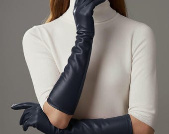 May include: Navy blue leather gloves, extending well past the elbows. The gloves are smooth and form-fitting, with a slight sheen. The image shows the gloves in a studio setting, highlighting their sleek design and elegant style.