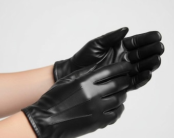 Puede incluir: Un par de guantes de cuero negro. Los guantes son lisos y brillantes, con detalles de costura visibles en la parte posterior. Los guantes se muestran sobre un fondo blanco liso.