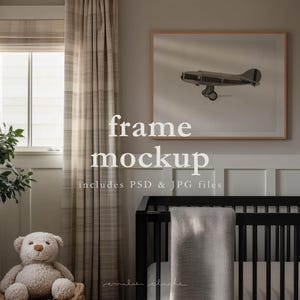 May include: A framed print of an aeroplane hangs above a black cot with a grey blanket. A teddy bear sits near a window with beige plaid curtains. The text "frame mockup" and "includes PSD & JPG files" is visible.