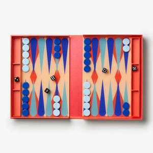 May include: A backgammon set in a coral-coloured case. The game board has a geometric design in blue, teal, and peach. Includes blue and light blue game pieces, and black dice. A classic board game for two players.