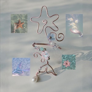 May include: A copper-colored wire ear cuff with a starfish design, adorned with light blue flowers, beads, and a dangling pearl. The image includes small square photos of a starfish, fish, and a flower.