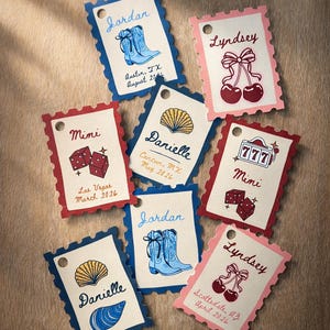 Puede incluir: Una colección de etiquetas personalizadas con bordes festoneados. Cada etiqueta presenta un nombre, una ilustración gráfica y una ubicación con una fecha. Los gráficos incluyen botas de vaquero, dados, cerezas, una concha y una máquina tragamonedas.