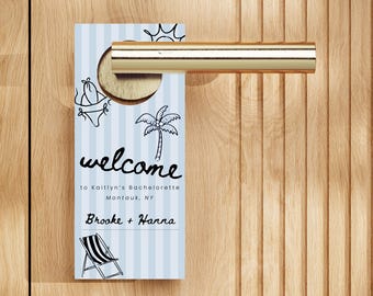 May include: A light blue door hanger with vertical white stripes, featuring a welcome message for a bachelorette party. The design includes a bikini, palm tree, sun, and beach chair illustrations. The door hanger is hanging on a wooden door.