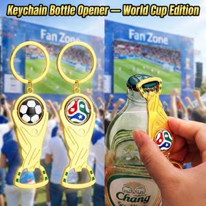 Peut inclure: Décapsuleurs porte-clés dorés avec un ballon de football et un emblème coloré. Les décapsuleurs ont la forme d'un trophée. Le texte "Keychain Bottle Opener - World Cup Edition" est en haut de l'image.