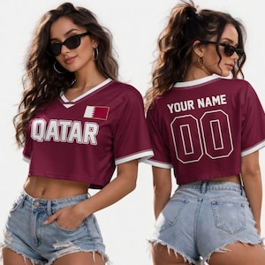 Peut inclure: Haut de maillot de corps bordeaux avec bordure blanche et le mot "QATAR" en lettres majuscules blanches. Le maillot porte un &eacute;cusson du drapeau du Qatar et peut &ecirc;tre personnalis&eacute; avec un nom et un num&eacute;ro au dos. Le mod&egrave;le porte un short en jean.