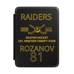May include: Black rectangular case with gold text. The text reads "RAIDERS BOS MA" above crossed hockey sticks and a puck. Below, it says "BOSTON HOCKEY EST. NINETEEN TWENTY-FOUR". The name "ROZANOV" and the number "81" are at the bottom.