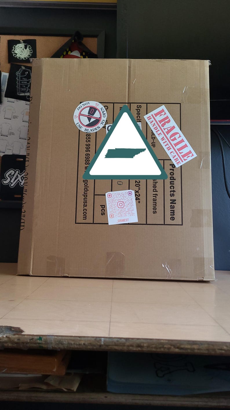 K&ouml;nnte beinhalten: Ein gro&szlig;er Karton mit verschiedenen Etiketten, darunter "FRAGILE" und "HANDLE WITH CARE." Die Box hat auch einen Aufkleber mit dem Text "DO NOT USE BLADES." Die Box enth&auml;lt "shed frames" und misst 50.8cm x 61cm.
