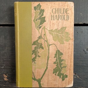 May include: Vintage hardcover book titled "Childe Harold" with a light brown cover featuring a green and light green leaf design. The spine is a solid olive green. The book is in good condition.