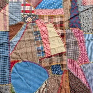 May include: A patchwork quilt with a variety of fabric patterns and colors. The quilt features geometric shapes and a mix of floral, plaid, and striped fabrics. The edges are stitched with yellow, red, and blue thread.