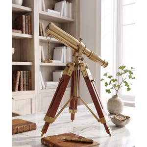 Peut inclure: Un télescope en laiton monté sur un trépied en bois avec des ferrures en laiton. Le télescope présente un corps cylindrique avec un oculaire réglable et un petit capuchon d'objectif attaché par une chaîne. Les pieds du trépied sont en bois foncé.